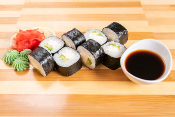 Sushi, maki, with curd cheese and avocado. On the plank.