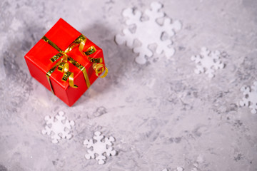 Christmas or winter gift. Red box packed with white snowflakes on a gray background. Holiday, New Year. Flat lay, top view, space for text.present