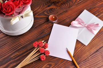 Gift box with flowers on wooden background, preparation for the holiday concept. Top view and copy area for text.
