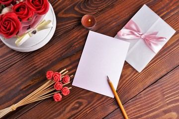 Gift box with flowers on wooden background, preparation for the holiday concept. Top view and copy area for text.
