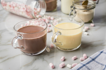 Obraz na płótnie Canvas Zubereitung von heißer, dunkle und weiße Trinkschokolade mit Milch, Kakaopulver und Marshmellows auf Marmor hell Hintergrund 