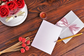 Gift box with flowers on wooden background, preparation for the holiday concept. Top view and copy area for text.