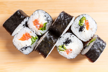 Simple poppies with salmon, avocado, cheese and flying fish caviar. On the plank.