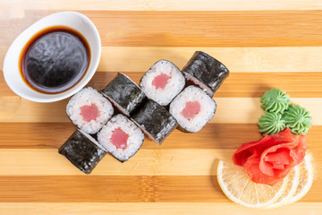Sushi, tuna rolls, On the plank. On a red background.