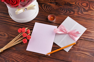 Gift box with flowers on wooden background, preparation for the holiday concept. Top view and copy area for text.