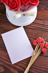 Gift box with flowers on wooden background, preparation for the holiday concept. Top view and copy area for text.