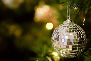 Closeup Crystal ball Decorated on Pine Tree on Christmas night with blurry background and bokeh of Christmas lighting.