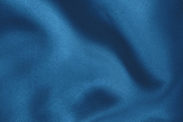 Dark blue colored Background of soft draped fabric. Beautiful satin silk textured cloth for making...