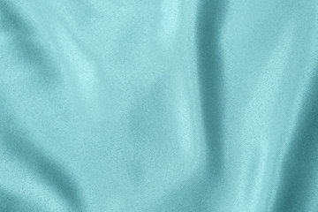 Light blue colored Background of soft draped fabric. Beautiful satin silk textured cloth for making clothes and curtains. Elegant textile texture.