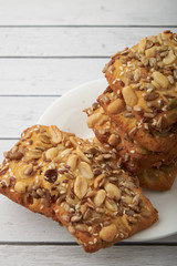 oat cookies chips and ingredients banana walnuts almonds raisin dried apricots on wooden table soft focus close up