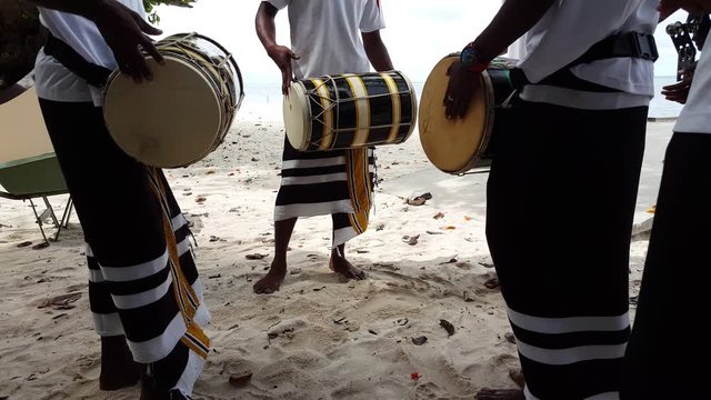 Group of trios playing bodu beru, a traditional Maldivian drum made of wood from coconut tree trunk