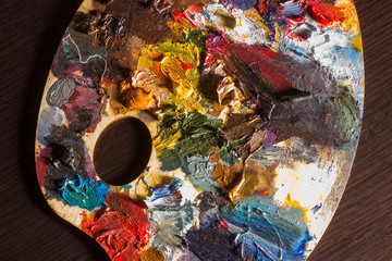 Artist's palette with oil paints, abstract background