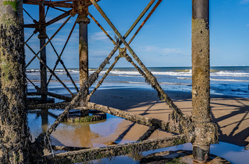 Fototapeta na wymiar 7 Under the boardwalk and among the iron work under Cromer pier on the Norfolk coast