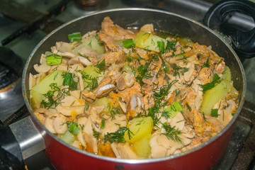 Meat with onions, carrots, potatoes, dill and Bay leaf is stewed in a saucepan. Home cooking.