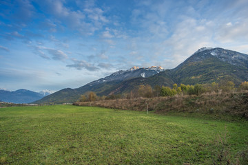 Countryside landscape with mountains in the background at blue hour.