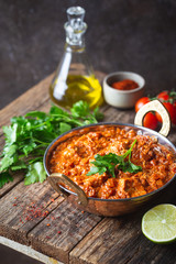 Chicken meat with tikka masala sauce, spicy curry food in iron copper pot with seasonings