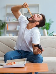 Man eating pizza having a takeaway at home relaxing resting