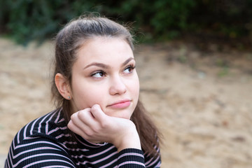 Fototapeta premium Confident and cheerful young woman looking away with her head resting on her hand 