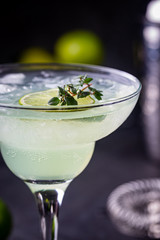 margarita cocktail with lime in a glass on dark background