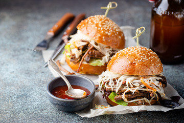 Pulled beef burger with cabbage salad and bbq sauce on paper