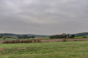 Rolling pasture in the Ardennes with a village in the background