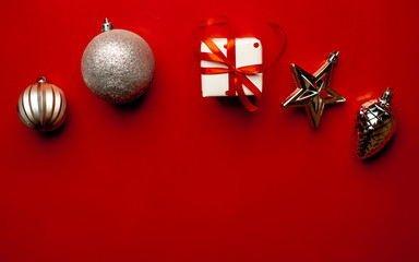 Christmas card with gift box and  toys on red background. Top view with place for your congratulations.