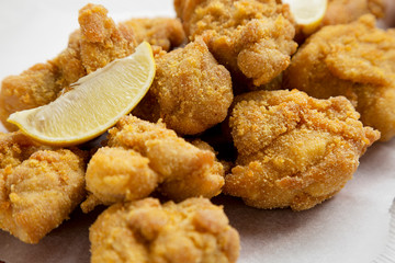 Homemade crispy japanese fried chicken Karaage on a rustic wooden board, side view. Close-up.