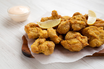 Homemade crispy japanese fried chicken Karaage on a rustic wooden board, side view. Closeup.
