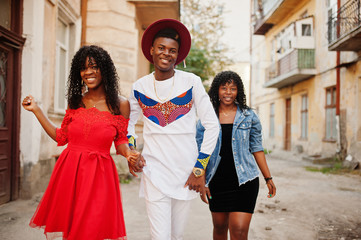 Obraz premium Group of three stylish trendy afro france friends posed at autumn day. Black african man model with two dark skinned womans.