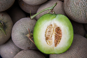 Cantaloupe cut half on pile of cantaloupe melon