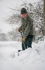 Man with a shovel cleans the track from the snow	