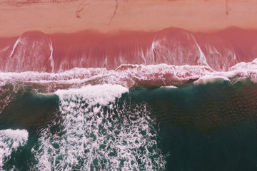 aerial view on ocean waves with white foam and turquoise water