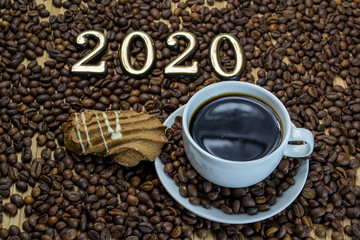 a cup of coffee with cookies, coffee grains scattered on a table near a cup with a coffee