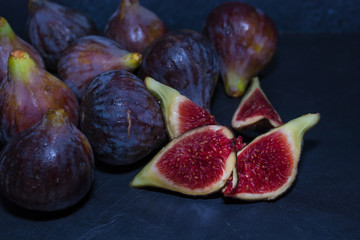 natural black figs grouped and open on black background
