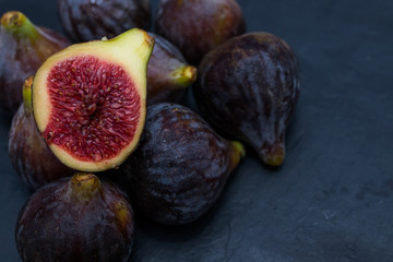 natural black figs grouped and open on black background