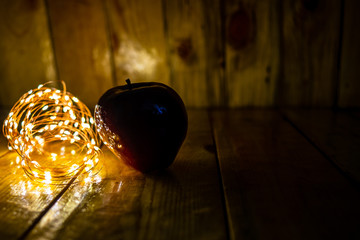 Naklejka na ściany i meble Red Apple on wood, with warm light, Good for christmas
