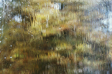 Rain drops on window glasses surface with bokeh background.