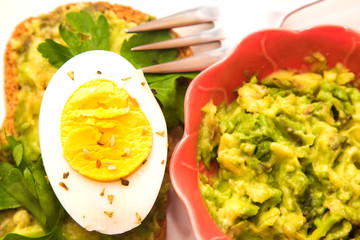 Guacamole toast and hard boiled egg with parsley