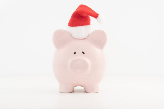 Concept image for savings planning featuring a pink piggy bank wearing a red Santa hat. 