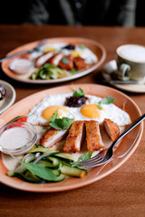 Fried eggs with chicken breast breaded. breakfast