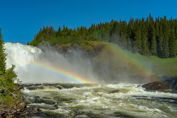 The waterfall Tannforsen in Sweden with rainbows in the mist