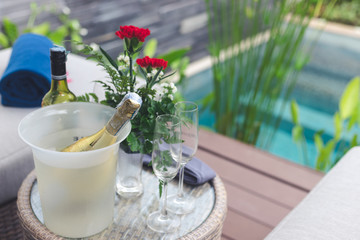 Wine set prepare for guest on the table near sofa with swimming pool nearby