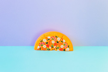 Half of tasty pizza is on the purple and blue background.  Minimalism. Fashion fast food