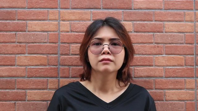 Young Asian woman wearing glasses feels bored.