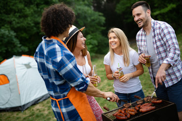Group of happy friends having outdoor barbecue party and fun together