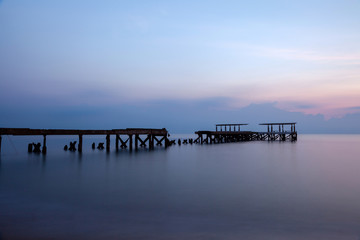 Fototapeta premium Old concrete bridges that melt on the beach by the sea in the morning, pastel tones, take long-exposure photos At Pran Buri Beach Prachuap Khiri Khan Province Thailand.