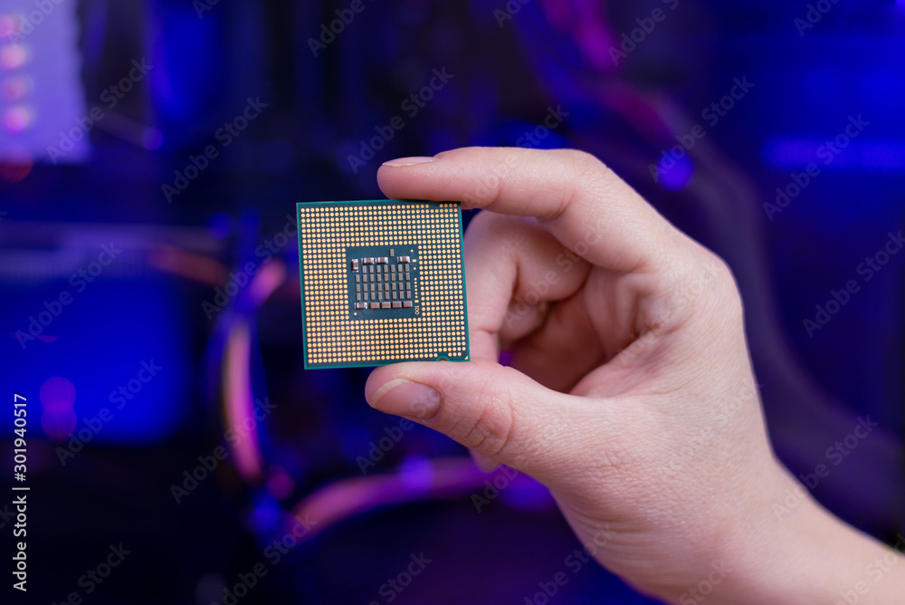 Poster back of a computer processor in hand. rgb light in background. close-up.