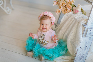 Image of sweet adorable baby girl in a wreath of pink roses, closeup portrait of cute 8 month-old smiling girl,  beautiful toddler.