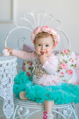 Fototapeta premium Image of sweet baby girl in a wreath, closeup portrait of cute 8 month-old smiling girl, toddler.