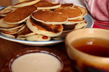 Breakfast with a cup of tea, sour cream and homemade pancakes